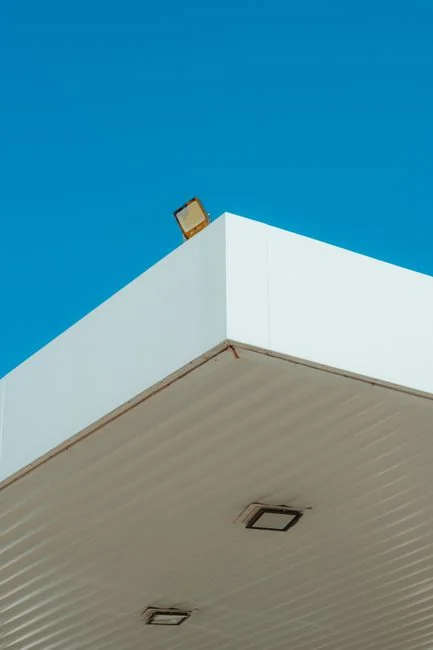Un homme nettoyant les fenêtres d'un gratte-ciel avec un harnais, illustrant le travail en hauteur en milieu urbain.